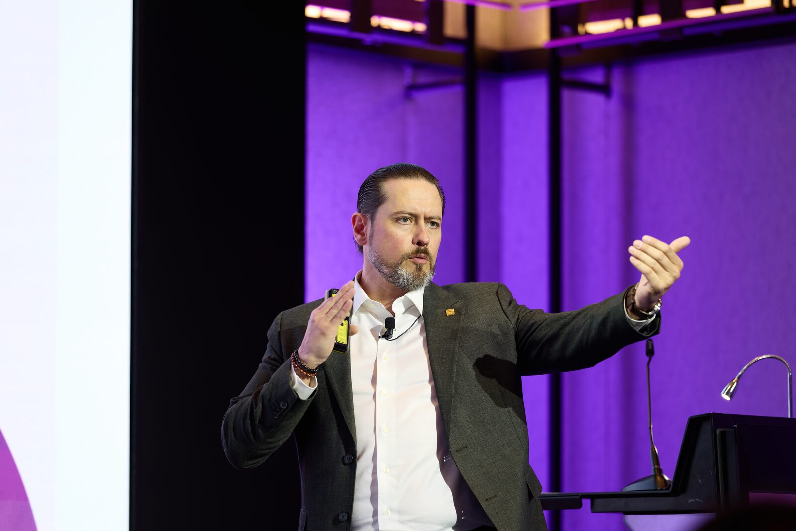 Speaker gesturing to the room during a conference keynote