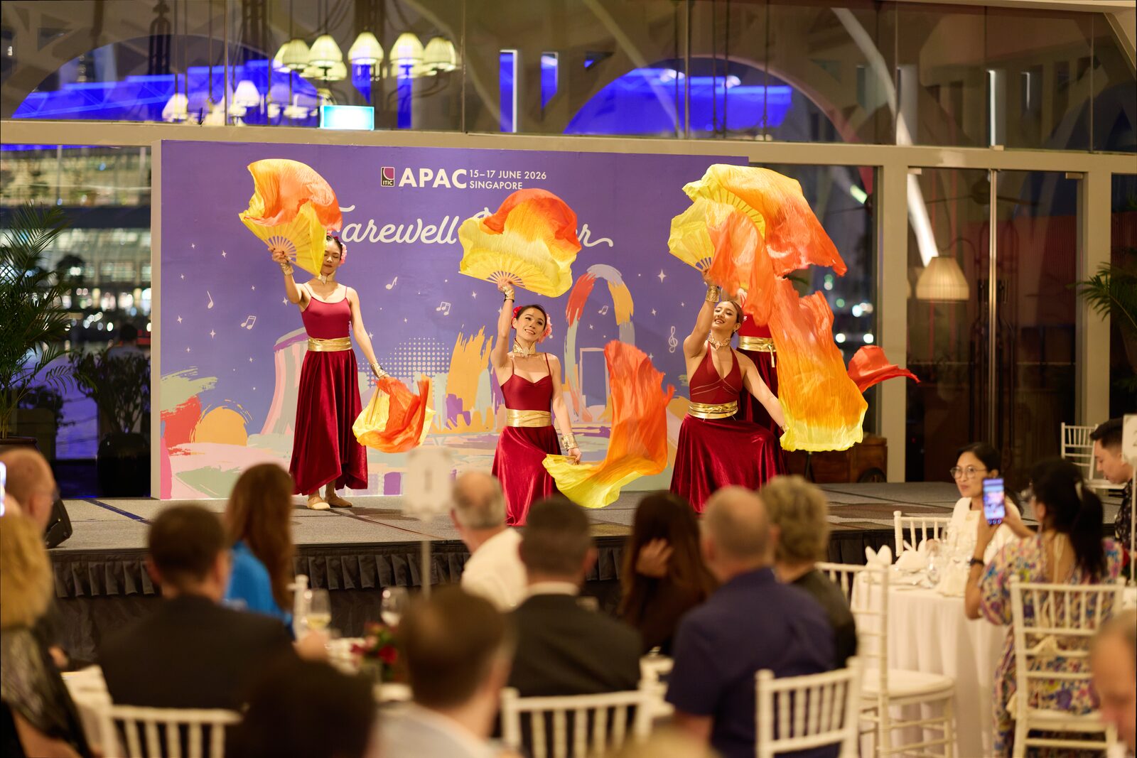 Dancers performing with silk fans at a gala dinner