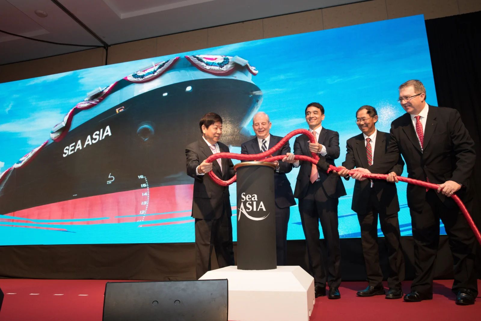 Executives at a vessel naming ceremony on stage